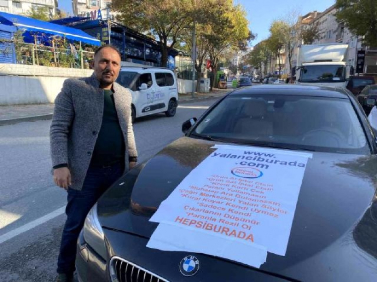 &quot;Alışveriş sitesi mağdur etti&quot; gerekçesiyle afiş bastırıp arabasına astı